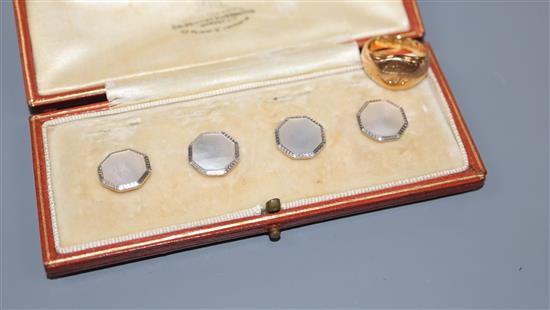 An early 20th century 18ct gold signet ring (worn) and an 18ct, plat and mother of pearl part stud set.